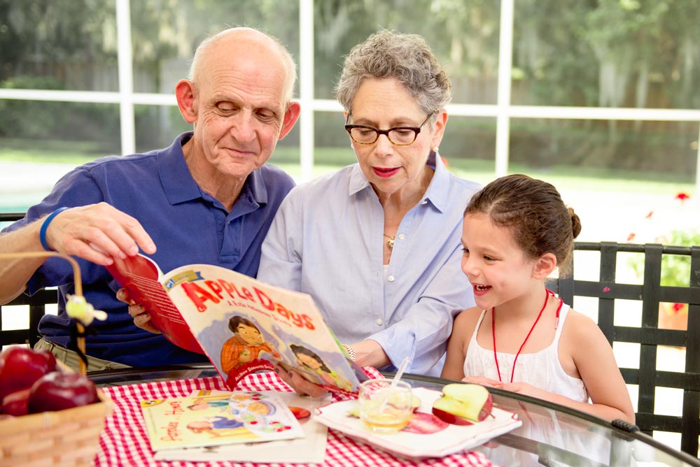 Little girl reading with grandparents